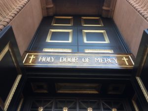 Picture of doors with the inscription "Holy doors of Mercy" showing that openness if required when it comes to addressing financial challenges